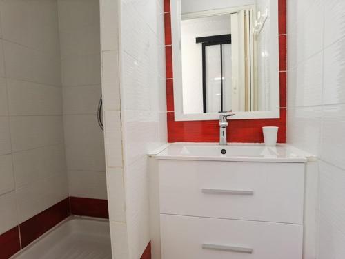 une salle de bain avec un lavabo blanc et un miroir dans l'établissement Appartement 2 pièces avec piscine et parking à Marseillan-Plage - FR-1-326-574, à Marseillan