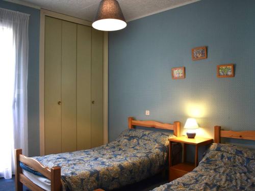 une chambre avec deux lits et une table avec une lampe dans l'établissement 3 pièces centre avec parking, Font-Romeu - FR-1-580-34, à Font-Romeu-Odeillo-Via