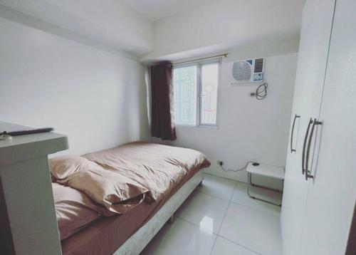 a small bedroom with a bed and a window at Sweden's Tiny Home, Studio Unit Condo in Manila