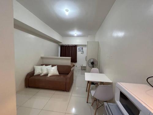 Sweden's Tiny Home, Studio Unit Condo في مانيلا: غرفة معيشة مع أريكة وطاولة