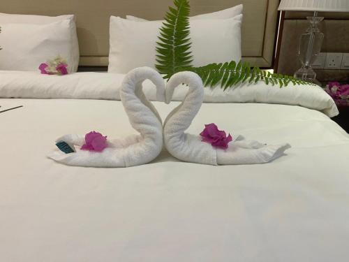 two swans shaped like hearts are sitting on a bed at Viluveli Holiday Retreat in Hanimaadhoo