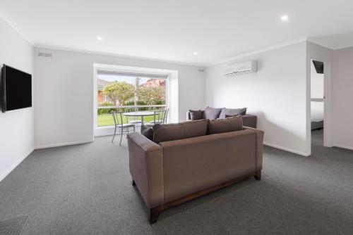 a living room with a couch and a table at Best Western Olde Maritime Motor Inn in Warrnambool