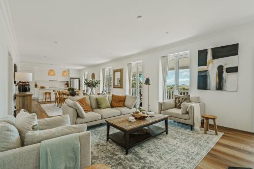 ein Wohnzimmer mit zwei Sofas und einem Tisch in der Unterkunft Willow House Gerringong in Rose Valley
