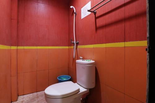 a bathroom with a toilet and a red and yellow wall at Penginapan Marsya Prima Syariah in Jakarta