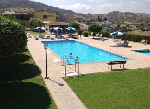 a swimming pool with people in a resort at Horizon Pissouri Bay 1 bedroom apartment with communal pool in Pissouri