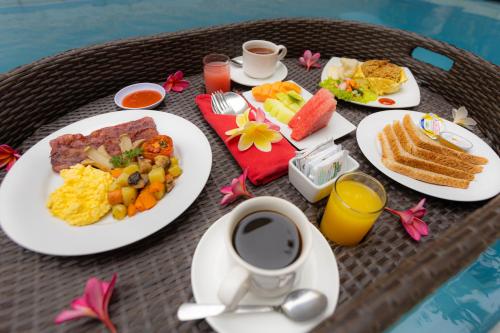 un tavolo con piatti per la colazione e una tazza di caffè di Luxotic Private Villa and Resort a Nusa Dua