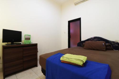 a bedroom with a bed and a tv on a dresser at Penginapan Marsya Prima Syariah in Jakarta