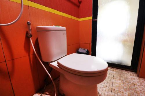 a bathroom with a toilet with a hose at Penginapan Marsya Prima Syariah in Jakarta