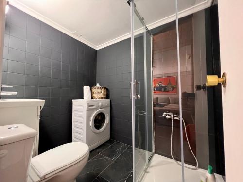 uma casa de banho com um WC e uma máquina de lavar roupa em Housingleon La Paloma em León