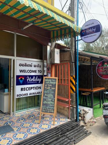 ein Restaurant mit einem Schild an der Seite eines Gebäudes in der Unterkunft Holiday Phangan - Hostel & Bar in Thongsala