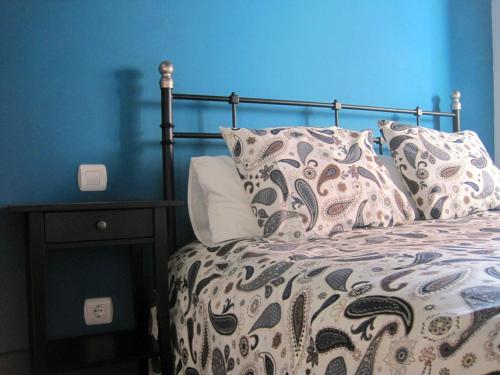 een blauwe slaapkamer met een bed met kussens erop bij La Casina de Piedra ENCANTO - Parte Antigua de Cáceres in Cáceres