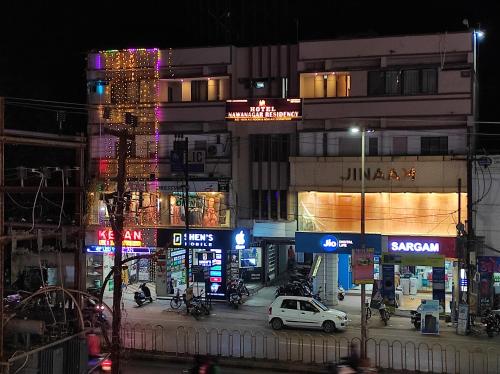 une rue de la ville la nuit avec des voitures et des bâtiments dans l'établissement Hotel Nawanagar Residency, à Jamnagar