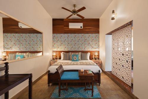 a bedroom with a bed and a table and a desk at Jaagir Manor, Dudhwa - IHCL SeleQtions in Paliā Kalān