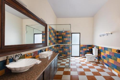 a bathroom with two sinks and a mirror at Jaagir Manor, Dudhwa - IHCL SeleQtions in Paliā Kalān