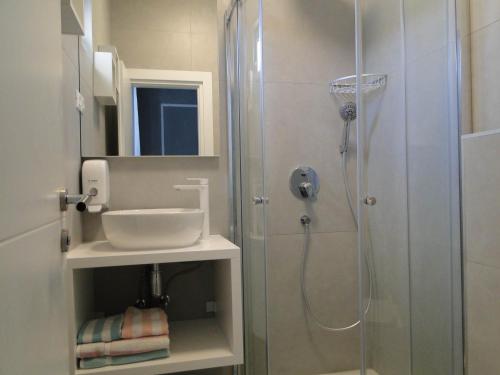 La salle de bains est pourvue d'une douche et d'un lavabo. dans l'établissement Rooms Tepli Bok, à Primošten