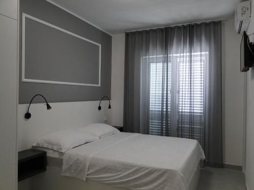 a bedroom with a bed and a large window at Rooms Tepli Bok in Primošten