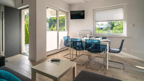 加茨比亞格拉的住宿－Turkusowy Klif，客厅配有桌子和蓝色椅子