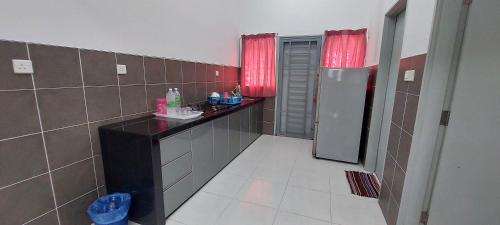 baño pequeño con fregadero y nevera en Hud Hud Homestay en Bandar Puncak Alam