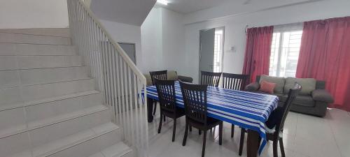 ein Esszimmer mit einem blauen Tisch und Stühlen in der Unterkunft Hud Hud Homestay in Bandar Puncak Alam