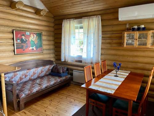 ein Wohnzimmer mit einem Sofa und einem Tisch in der Unterkunft Elämyksellinen huvila Tuurujärven rannalla. in Ulvila