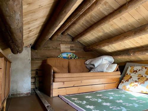 a room with a couch and a bed in a attic at Elämyksellinen huvila Tuurujärven rannalla. in Ulvila