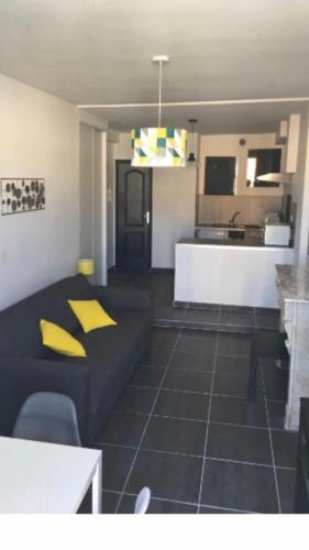 a living room with a couch and a kitchen at Superbe appartement sur quai centre ville in Sète