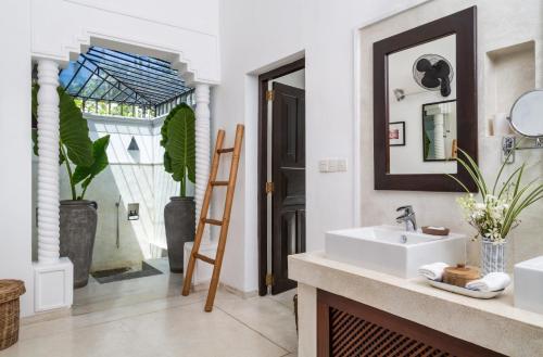 a bathroom with a sink and a mirror at Why House in Unawatuna