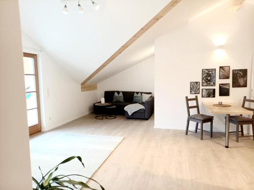 an attic living room with a couch and a table at Ferienwohnung Menter in Marquartstein