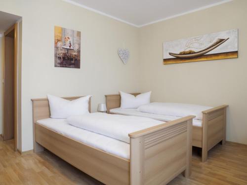 2 Betten in einem Zimmer mit weißen Wänden in der Unterkunft Hotel A8 Lukas in Augsburg