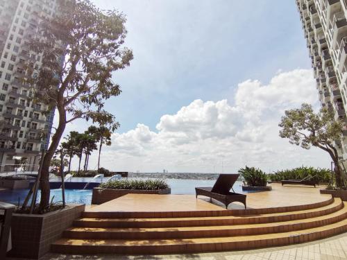 a bench sitting on a sidewalk next to a body of water at Benson Tower Surabaya Apartment 2BR by Le Ciel Hospitality in Lontar