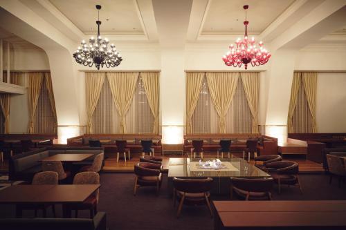 小樽市にあるOMO5小樽 by 星野リゾートのテーブルと椅子、シャンデリアのあるレストラン