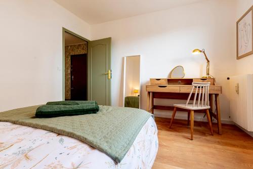 a bedroom with a bed and a desk and a chair at Le Jouvence Cozy - Confort - Zen - Parking gratuit in Dijon