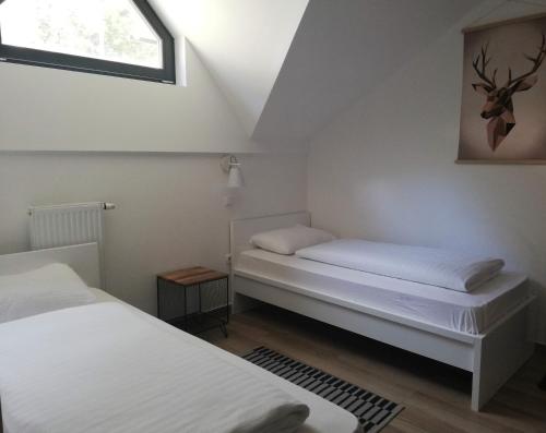 two beds in a small room with a window at Wellness Hotel Montis in Mozirje