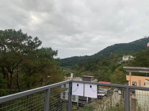 a balcony with a fence and a mountain at Svaneti Homestay Baguio in Baguio