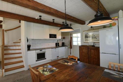 cocina con mesa de madera en una habitación en Valskott och mysig stuga i Gotlands Tofta, en Eskelhem