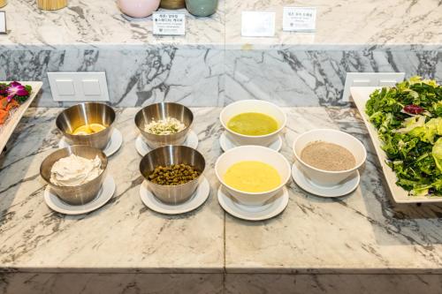 a table topped with bowls and plates of food at Gwangyang Lacky Hotel in Gwangyang