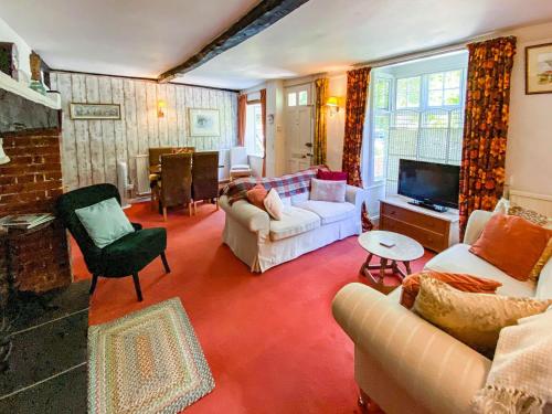 a living room with a couch and a tv at Quince Cottage in Saint Michaels