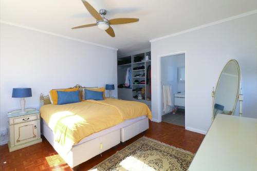 a bedroom with a bed and a ceiling fan at Royal House in Muizenberg