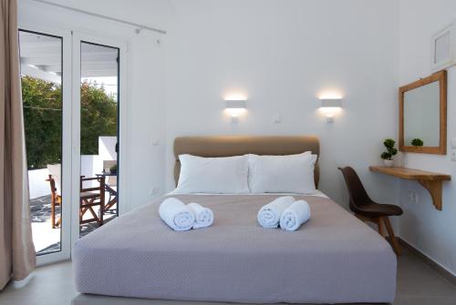 a bedroom with a bed with two towels on it at KALYPSO ACCOMMODATION SIFNOS in Vathi