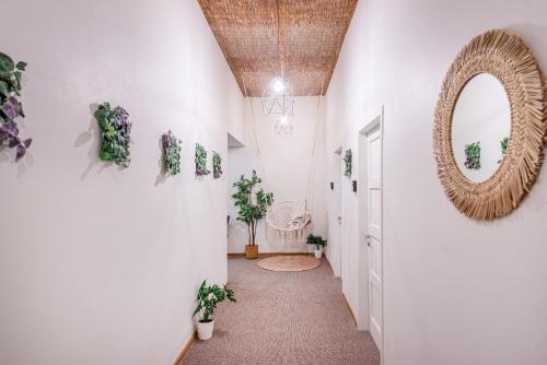 um corredor com um espelho e plantas nas paredes em Bali house Vilnius em Vilnius