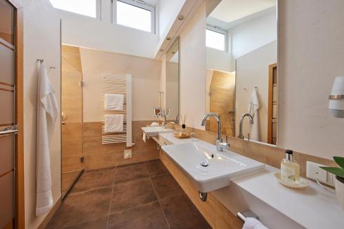 a bathroom with two sinks and a large mirror at Hotel Deimann in Schmallenberg