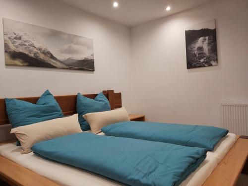 a bed with blue pillows on it in a room at Penthouse-Feeling MaBeA in Innsbruck