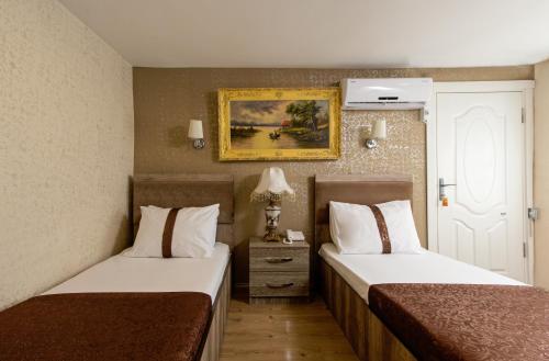 a hotel room with two beds and a picture on the wall at CARVAN SUİT in Istanbul