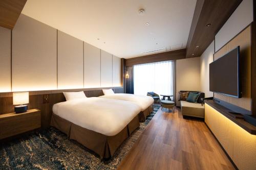 a hotel room with two beds and a flat screen tv at Beppu SUGINOI HOTEL in Beppu