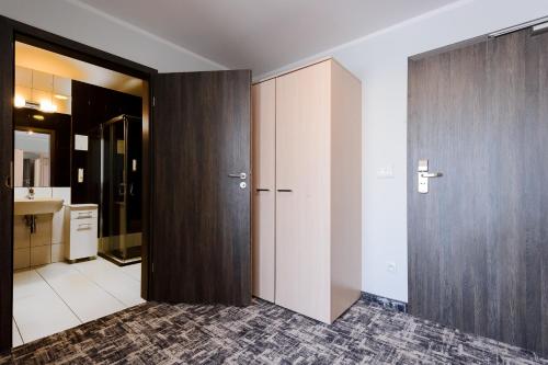 a bathroom with a large wooden closet and a sink at Centralny Ośrodek Sportu - Zakopane in Zakopane