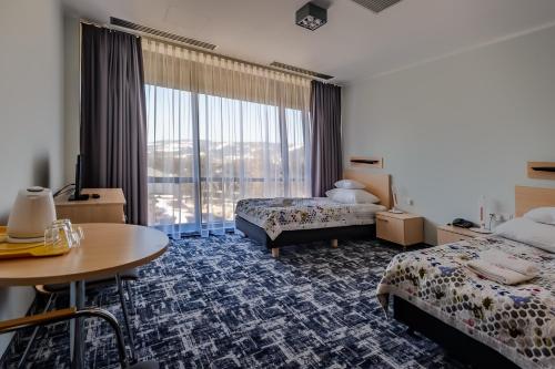 ein Hotelzimmer mit 2 Betten und einem Tisch in der Unterkunft Centralny Ośrodek Sportu - Zakopane in Zakopane