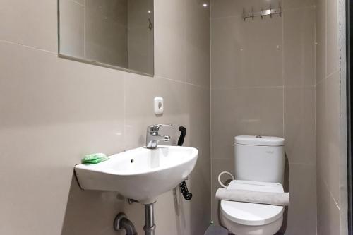 biała łazienka z umywalką i toaletą w obiekcie TwoSpaces Living at Pakis Residence w mieście Wonokitri 2