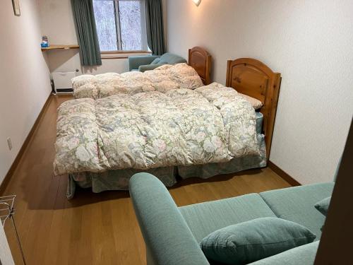 a bedroom with a bed and a couch at SkiHolic by TSH in Shinano