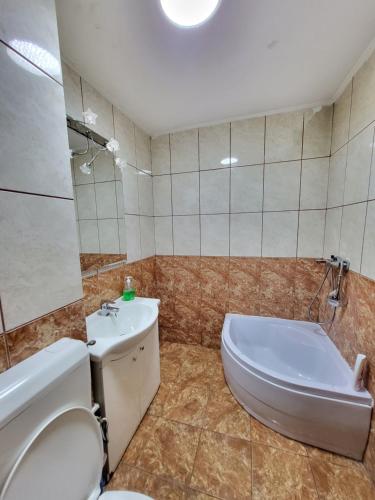 een badkamer met een bad, een toilet en een wastafel bij Avrig-Ferdinand Studio in Boekarest
