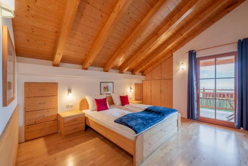 a bedroom with a bed and a large window at Weinberghof in Termeno